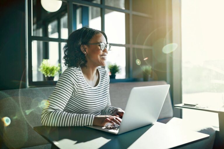 A girl using a laptop and smiling